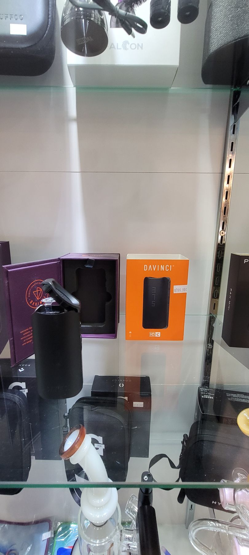 A display case filled with various smoking accessories, including vaporizers and water pipes.