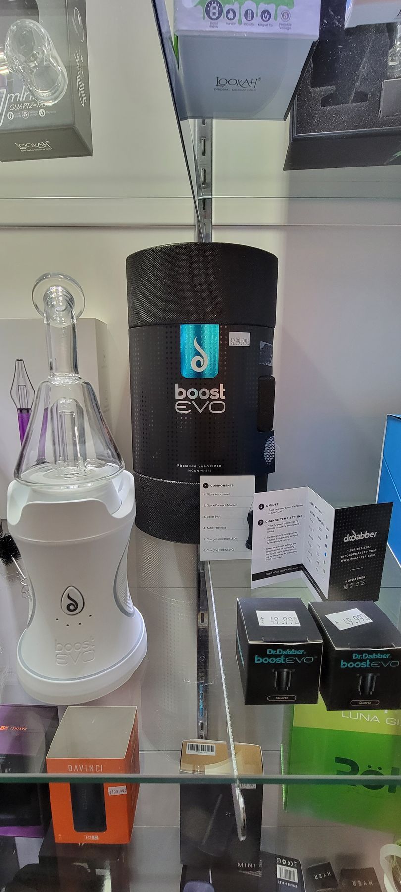 A display case in a store showcasing a vaporizer, its box, and accessories.