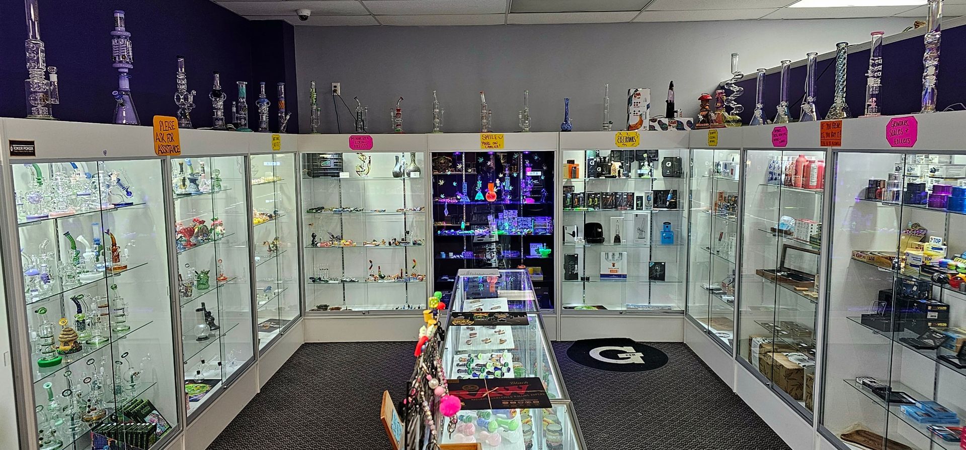 Inside of a glass shop with multiple displays of glass pipes and products.