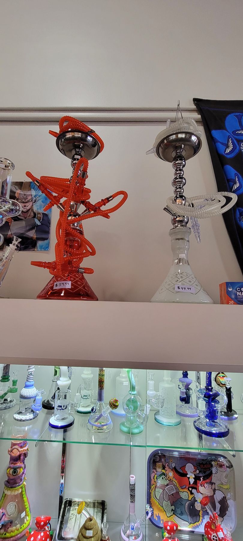 Hookahs of various colors and designs on display shelves in a shop.