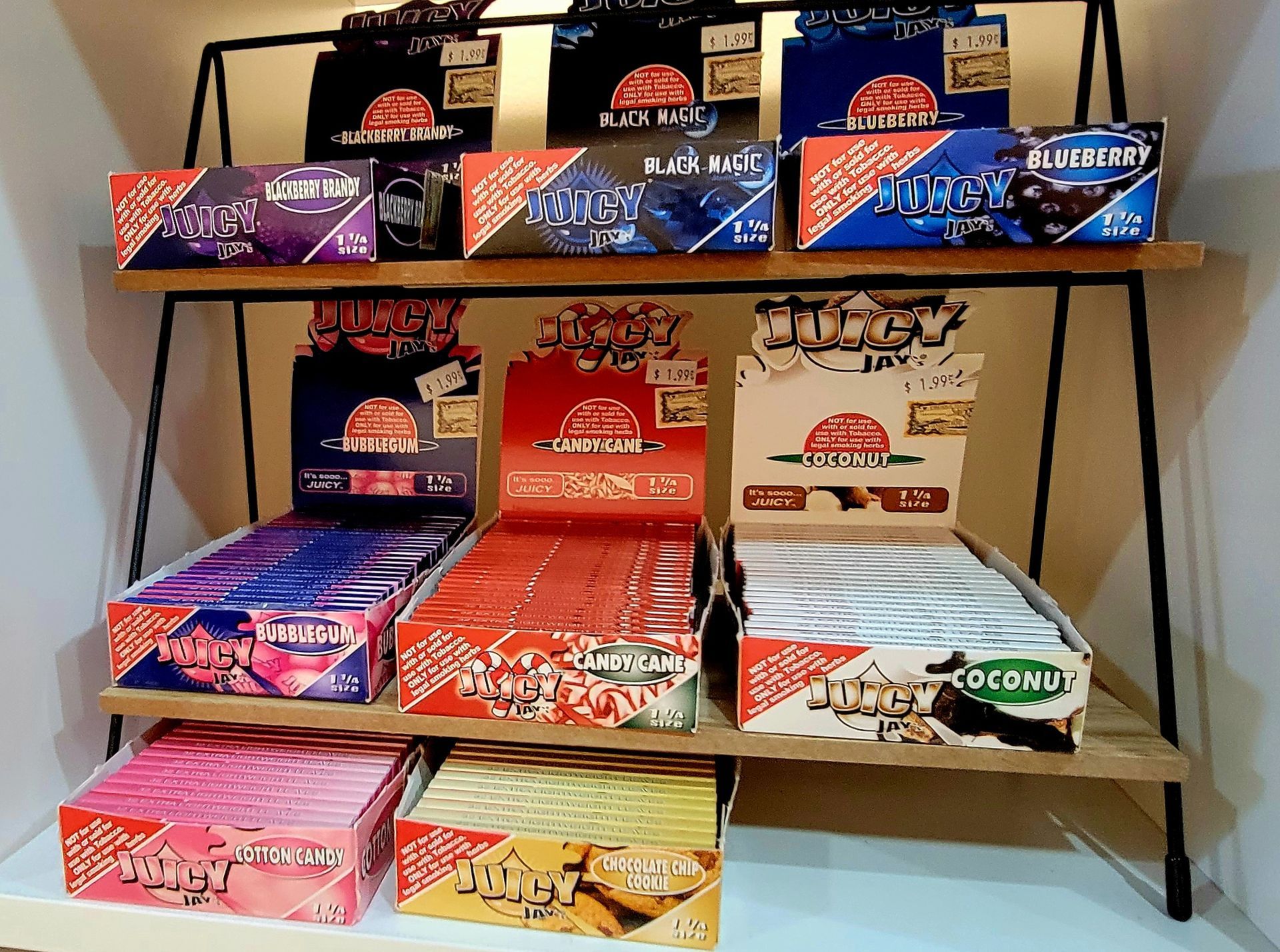 Display of Juicy Jay's flavored rolling papers in boxes on shelves.