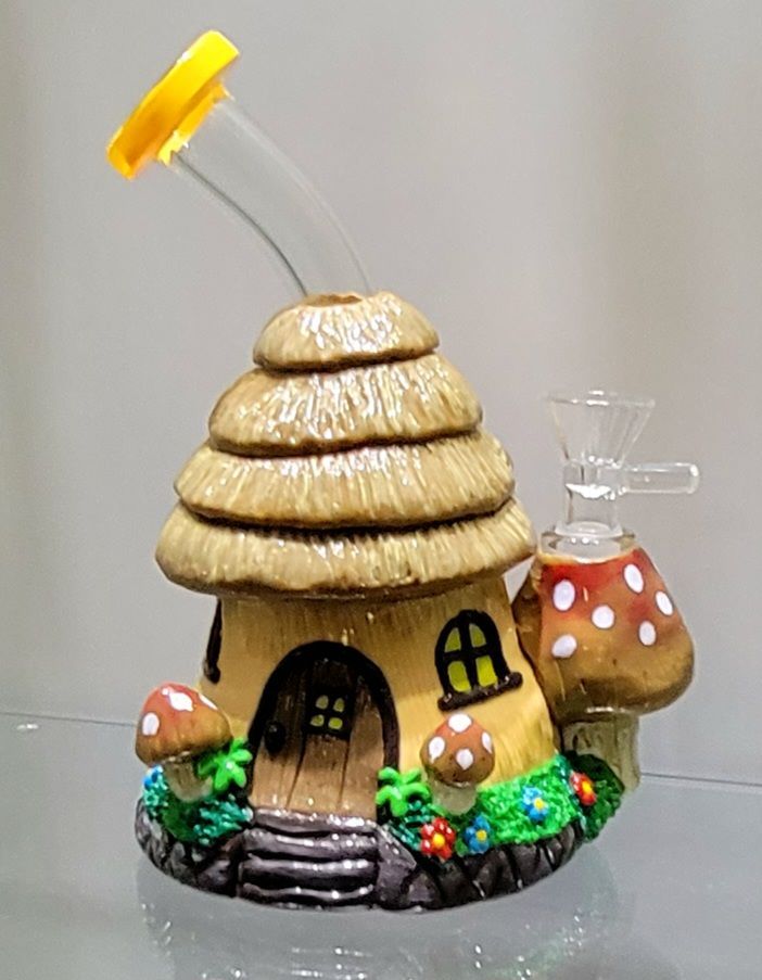 A mushroom-shaped bong with a yellow mouthpiece, brown and beige house design, and mushroom accents.