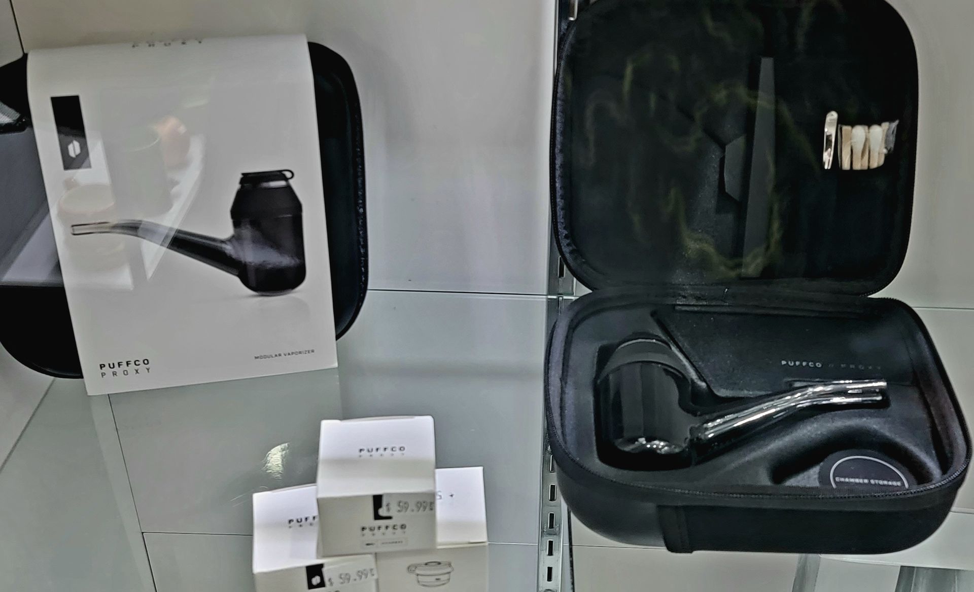 Black tobacco pipe in open case next to a closed box with a pipe illustration.