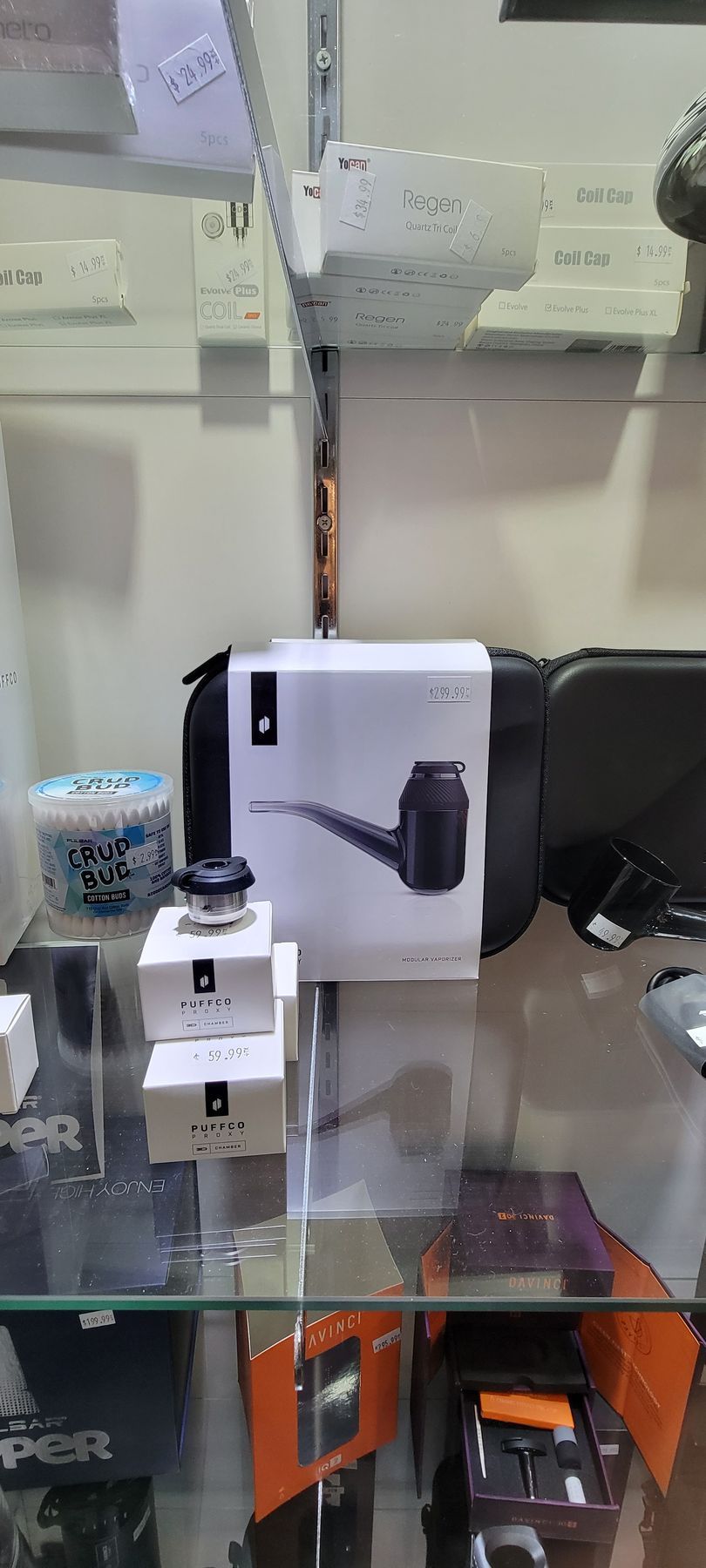 Display case with smoking pipes and accessories. White boxes, black pipe, blue and orange items.