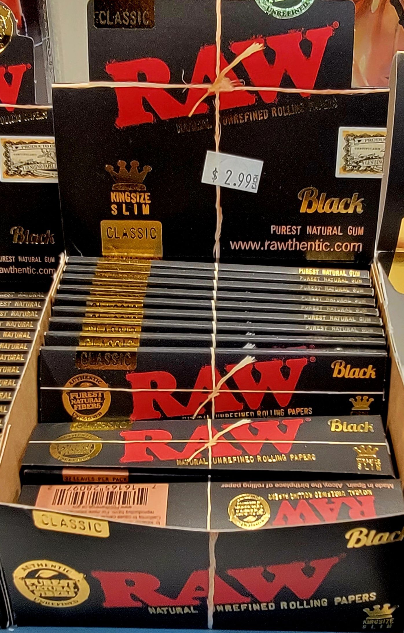 Display of Raw Black rolling papers in a store, black and red packaging.