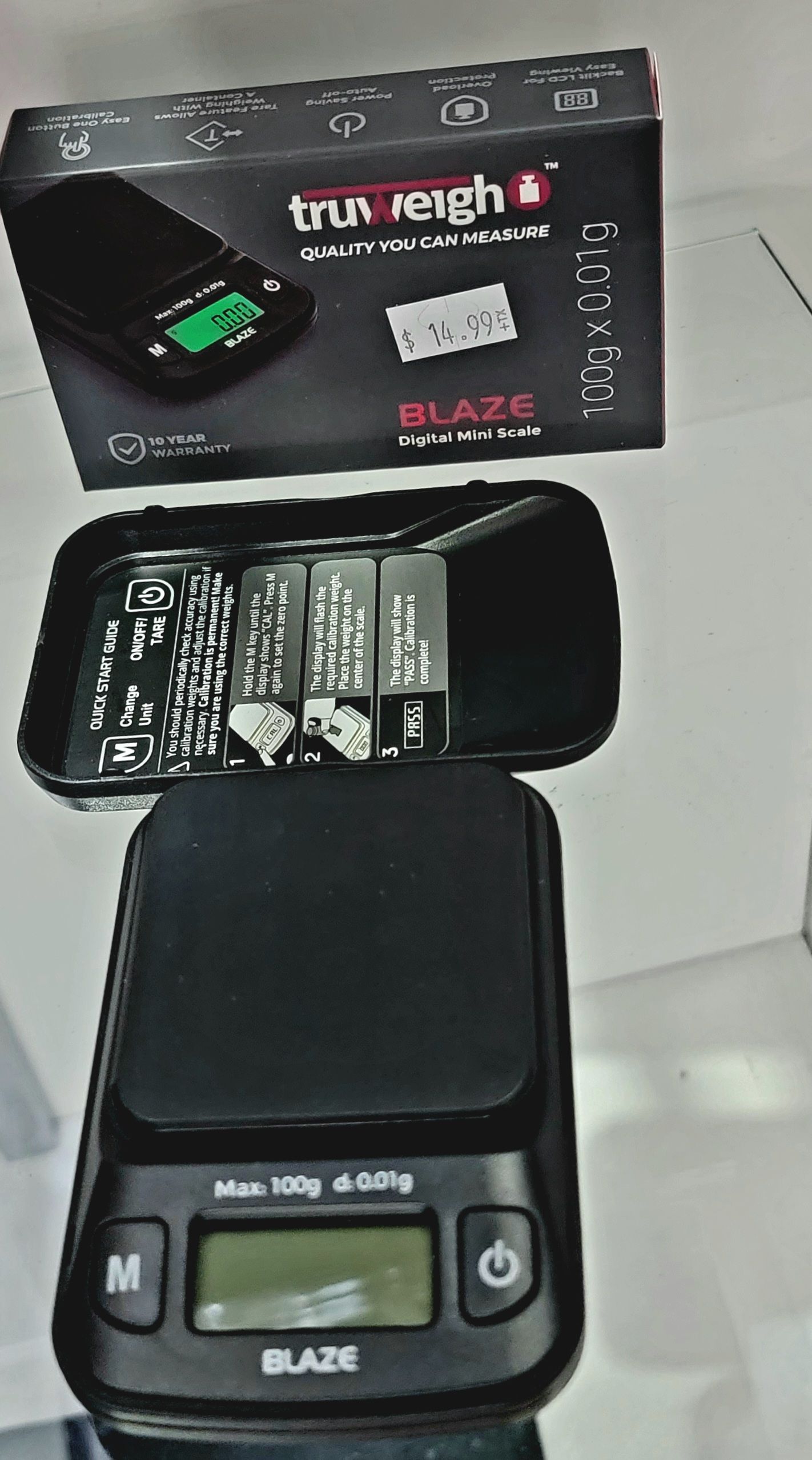 Black digital scale, Truweigh Blaze, with open box and battery compartment.