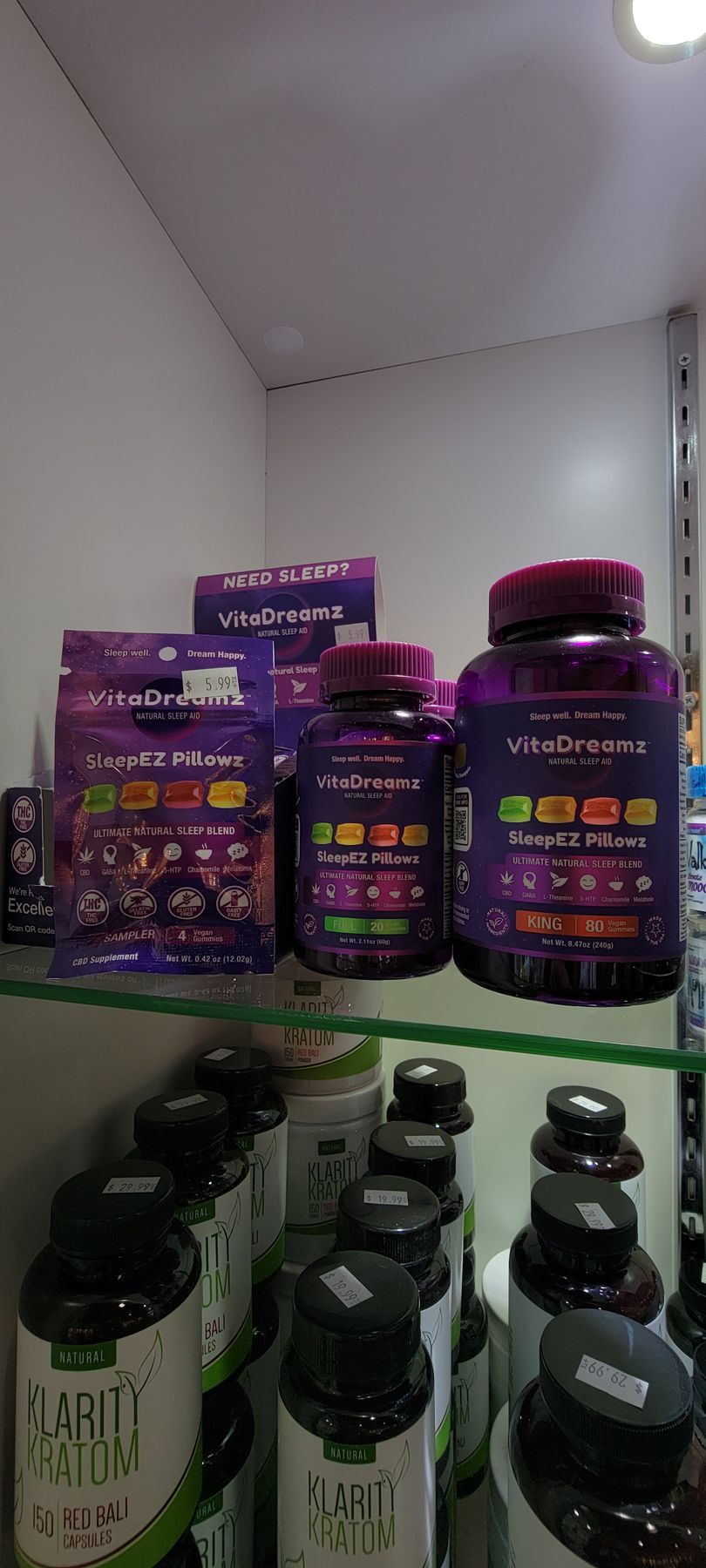 Shelves of supplements, purple containers with red caps.