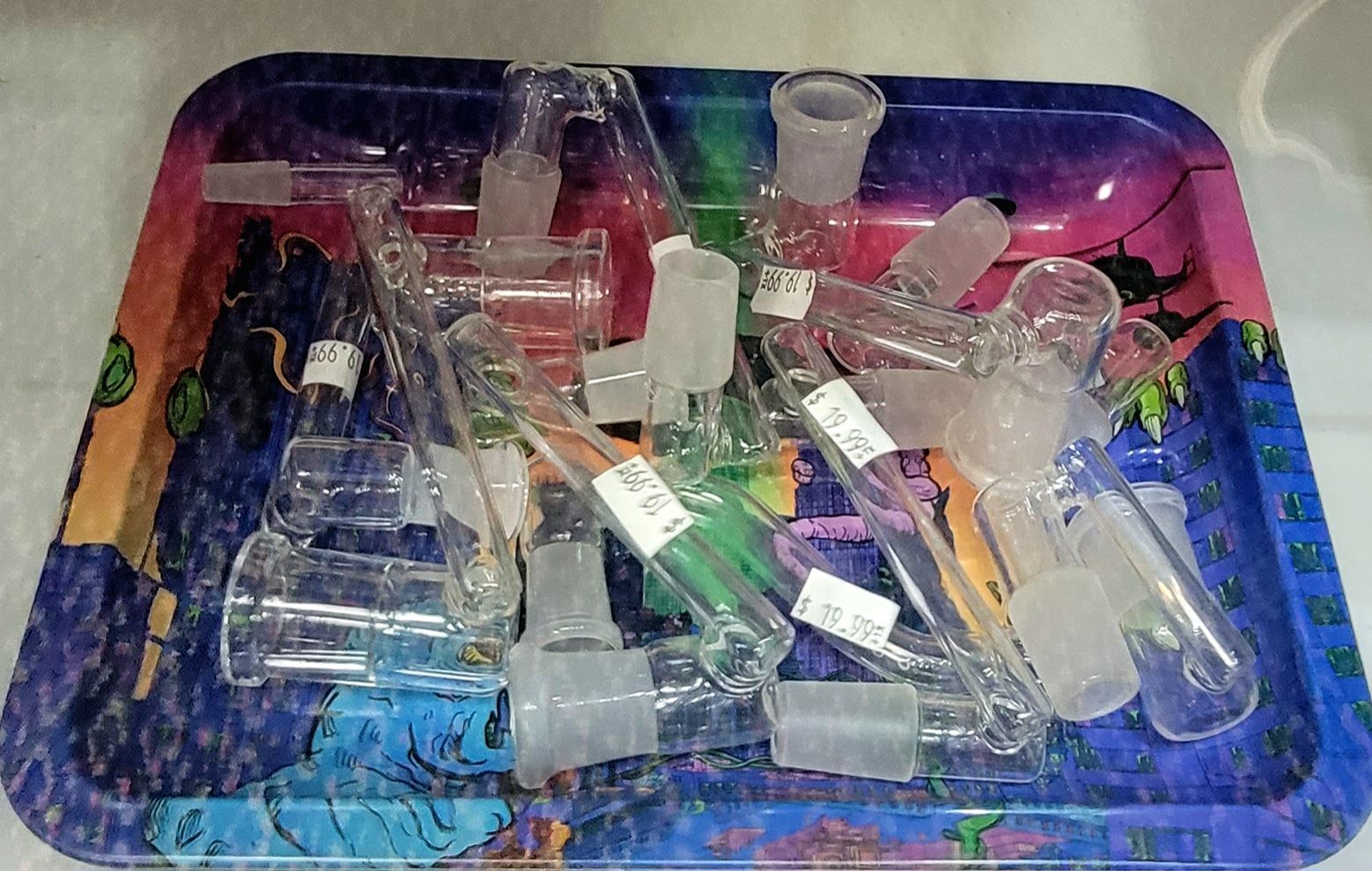 Glass smoking accessories on a colorful tray.