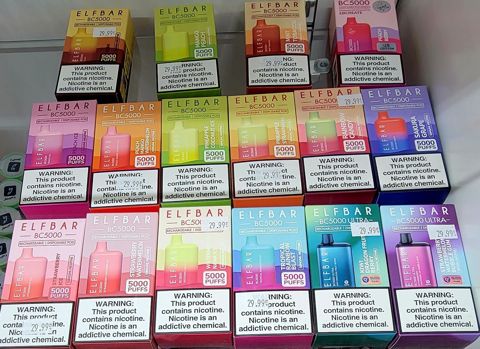 Shelves displaying colorful Elf Bar disposable vapes in various flavors.
