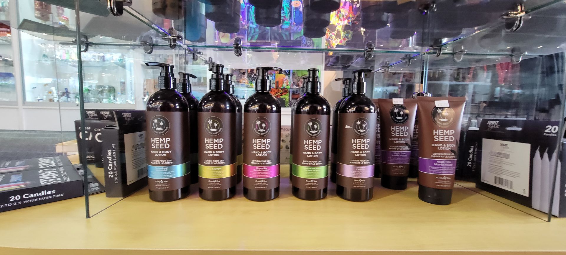 Bottles of shampoo and hair care products on a display shelf. Brown bottles with colorful labels are lined up.