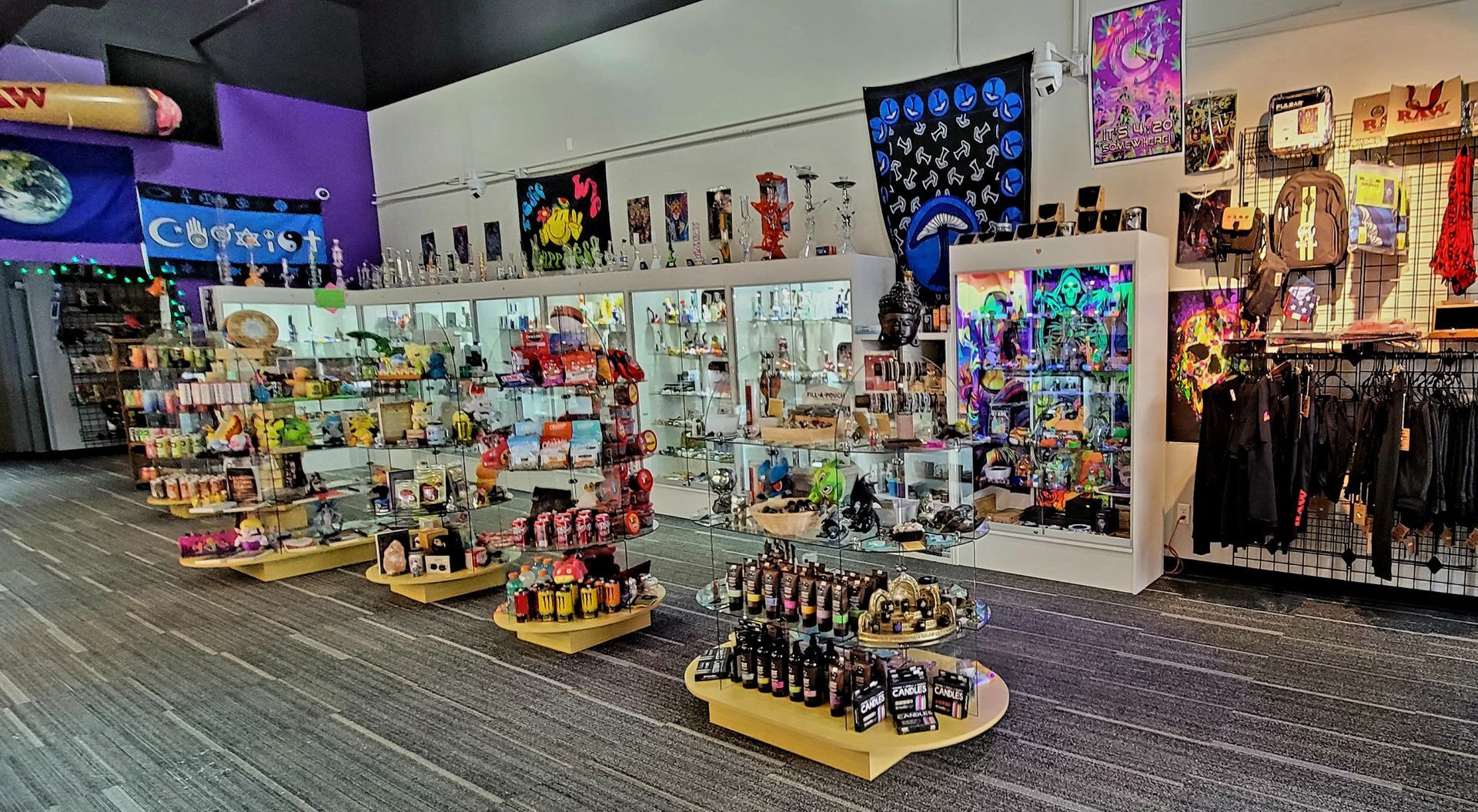 Interior of a colorful shop with display cases, shelves of merchandise, and clothing racks.