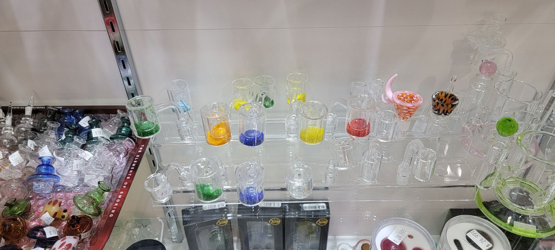 Row of colorful glass ornaments and bowls in a store.
