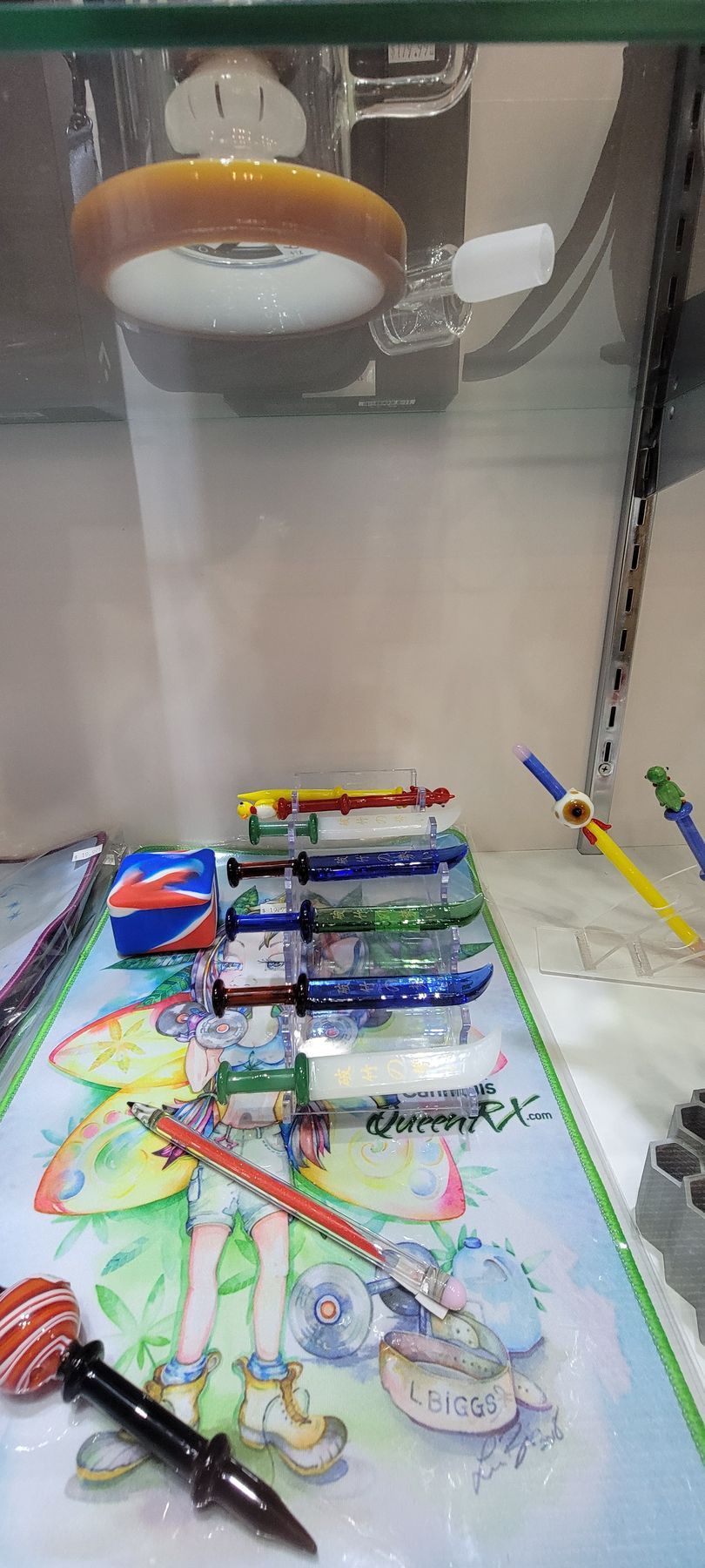 Display case with colorful items: a ring light, toy buses, and a drawing.