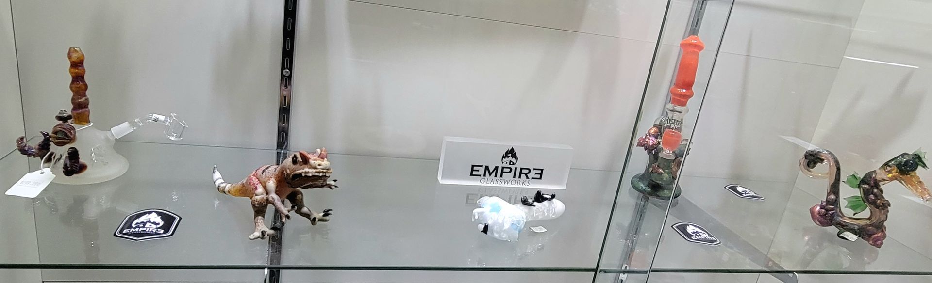 Display case with dinosaur figurines and a small white sculpture.