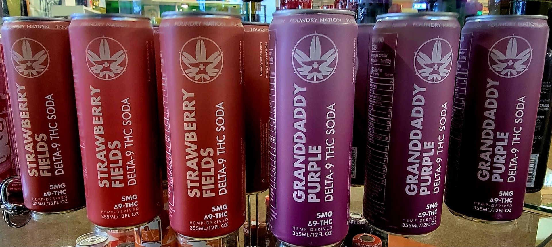 Red and purple cans of cannabis-infused soda, labeled 