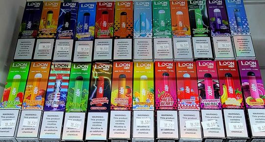 Rows of colorful disposable vapes with various flavors.