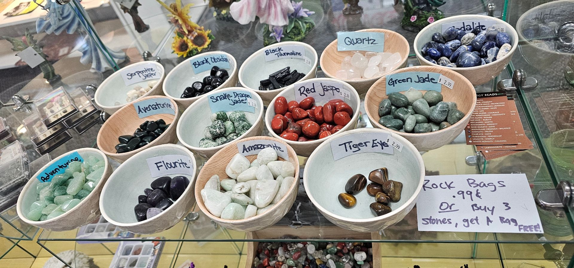 Bowls of polished stones on display, including Quartz, Garnet, and Tiger Eye.
