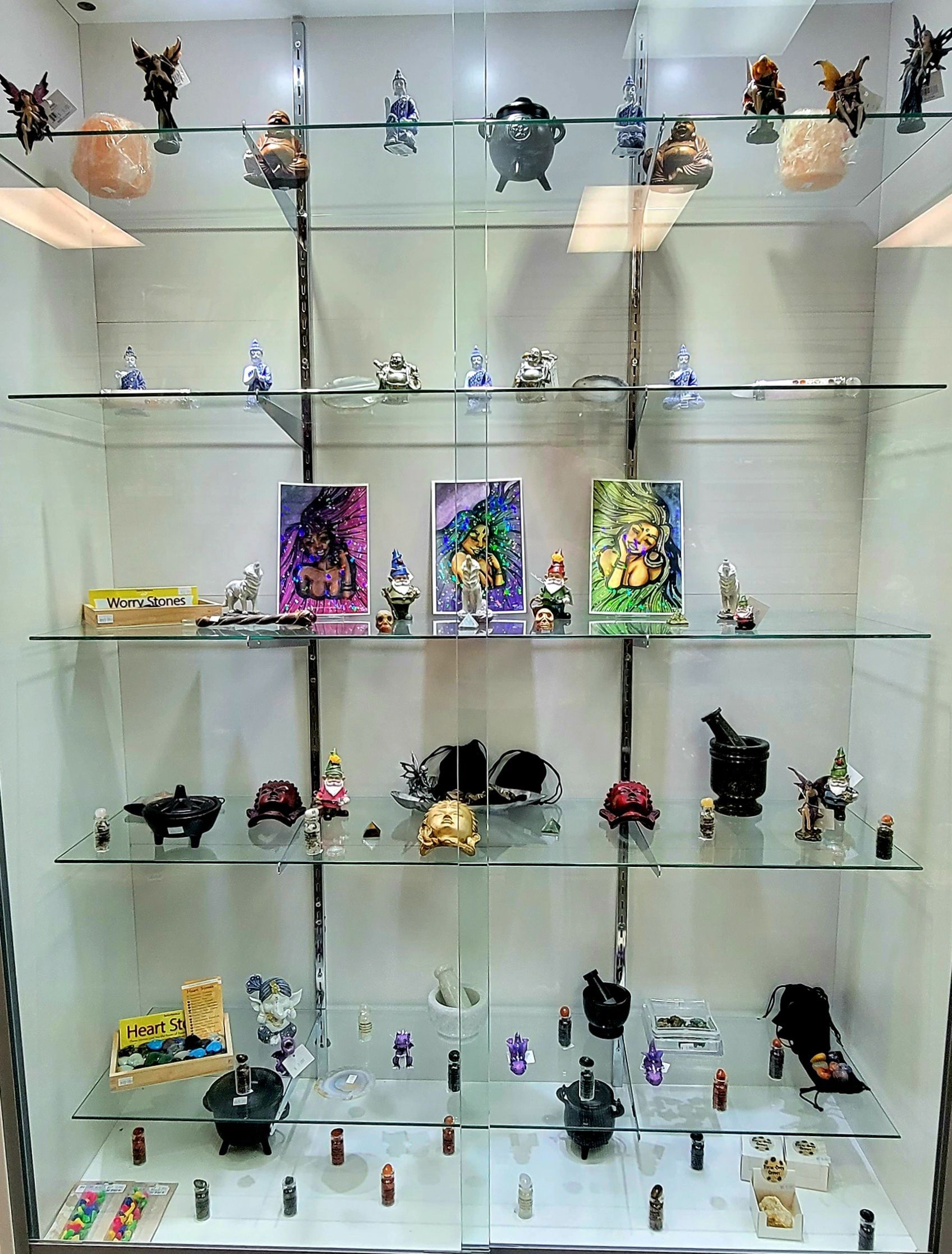 Glass display case filled with small art objects, including figurines, pottery, and framed pictures.