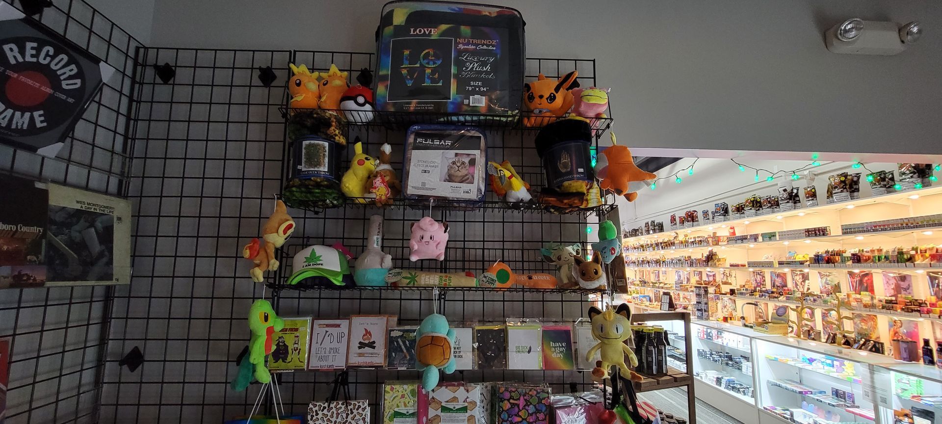 A store display with Pokemon plushies, keychains, and artwork. A 