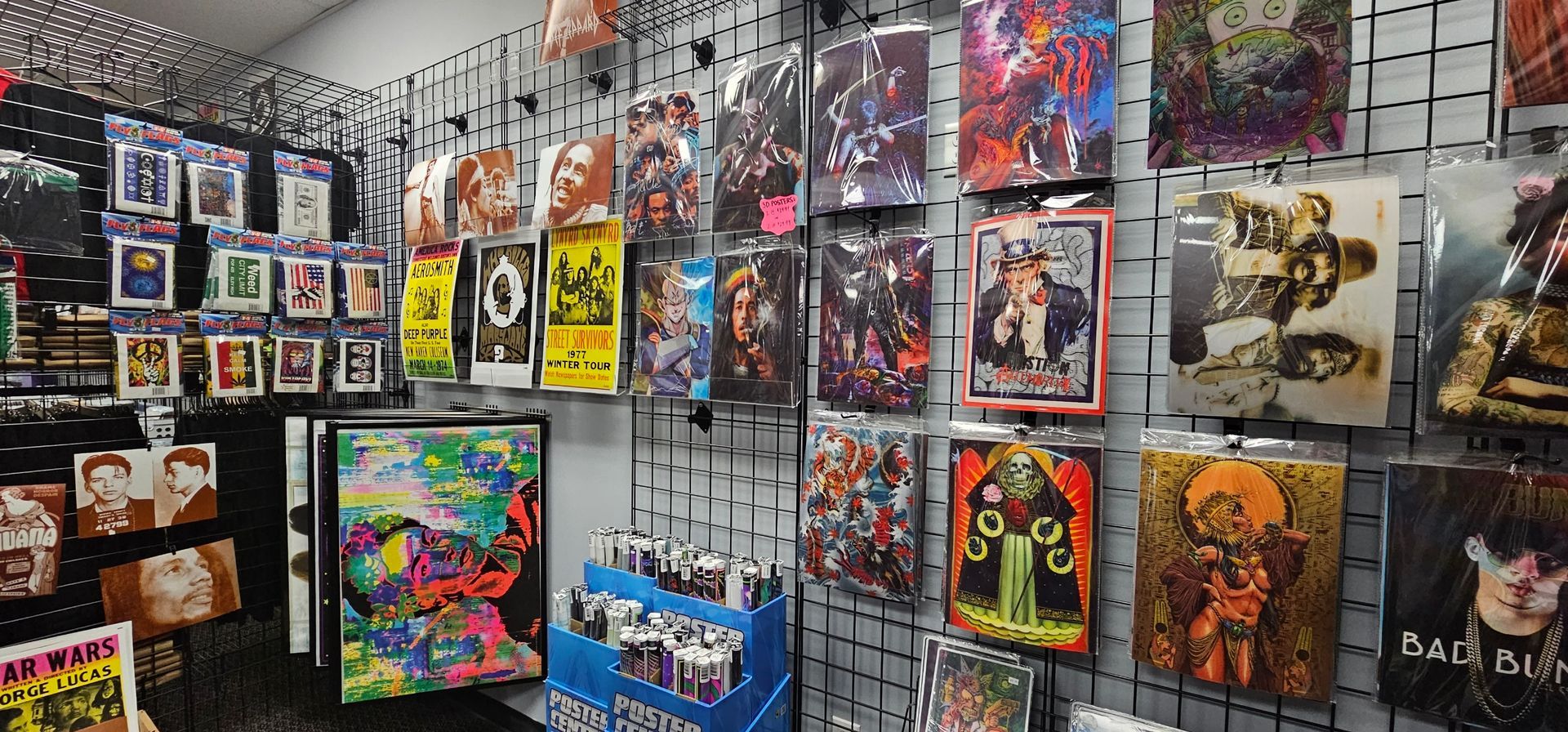 A shop display features various art prints and cards on black wire grids.