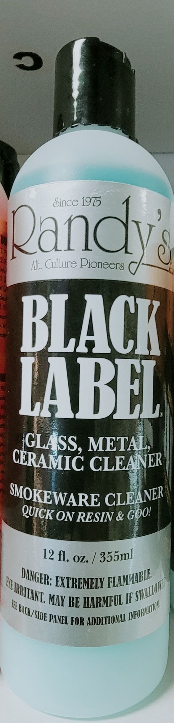 Bottle of Randy's Black Label cleaner. Glass, metal, and ceramic cleaner for smoking devices. Blue liquid in bottle.