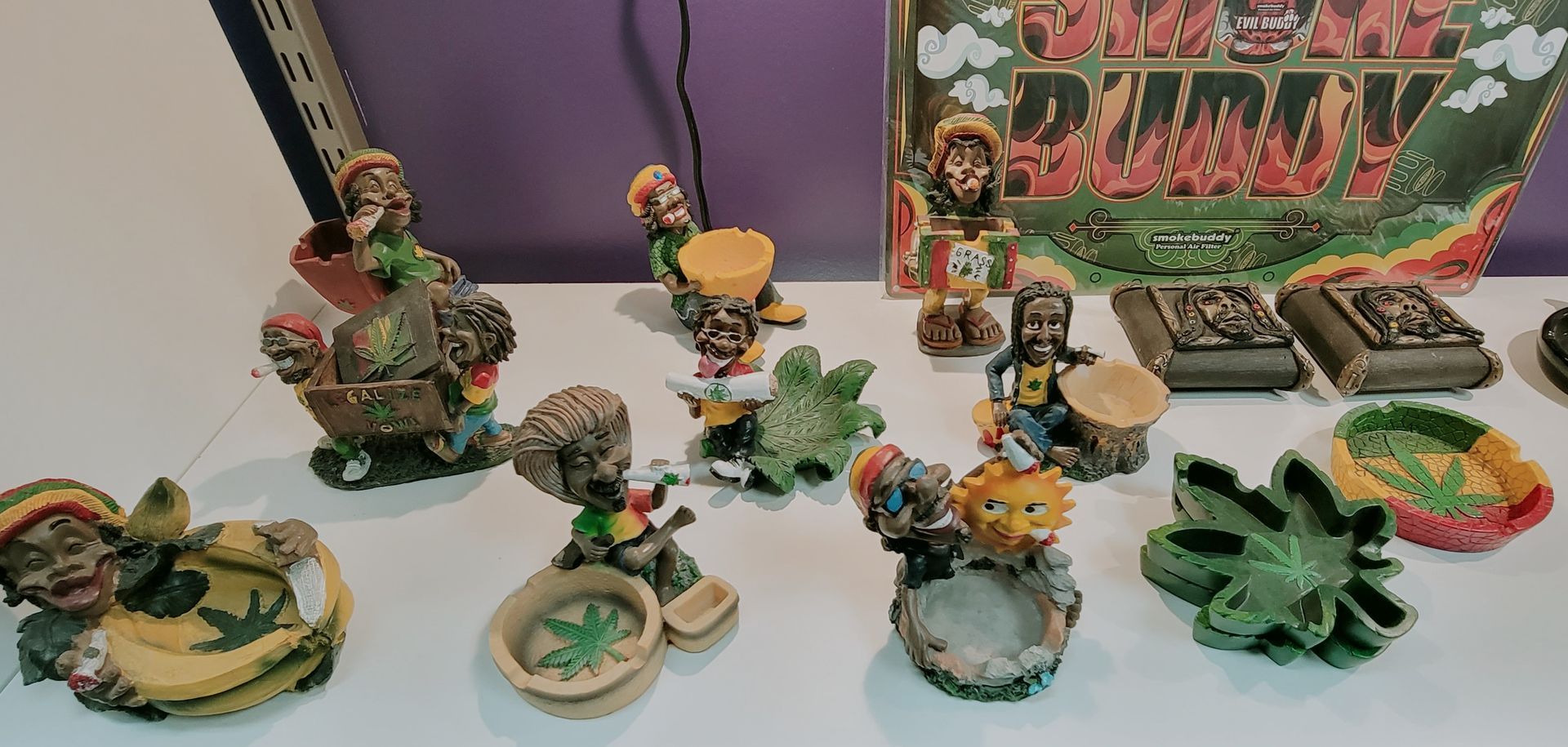Various figurines with Rastafarian themes displayed on a white surface.