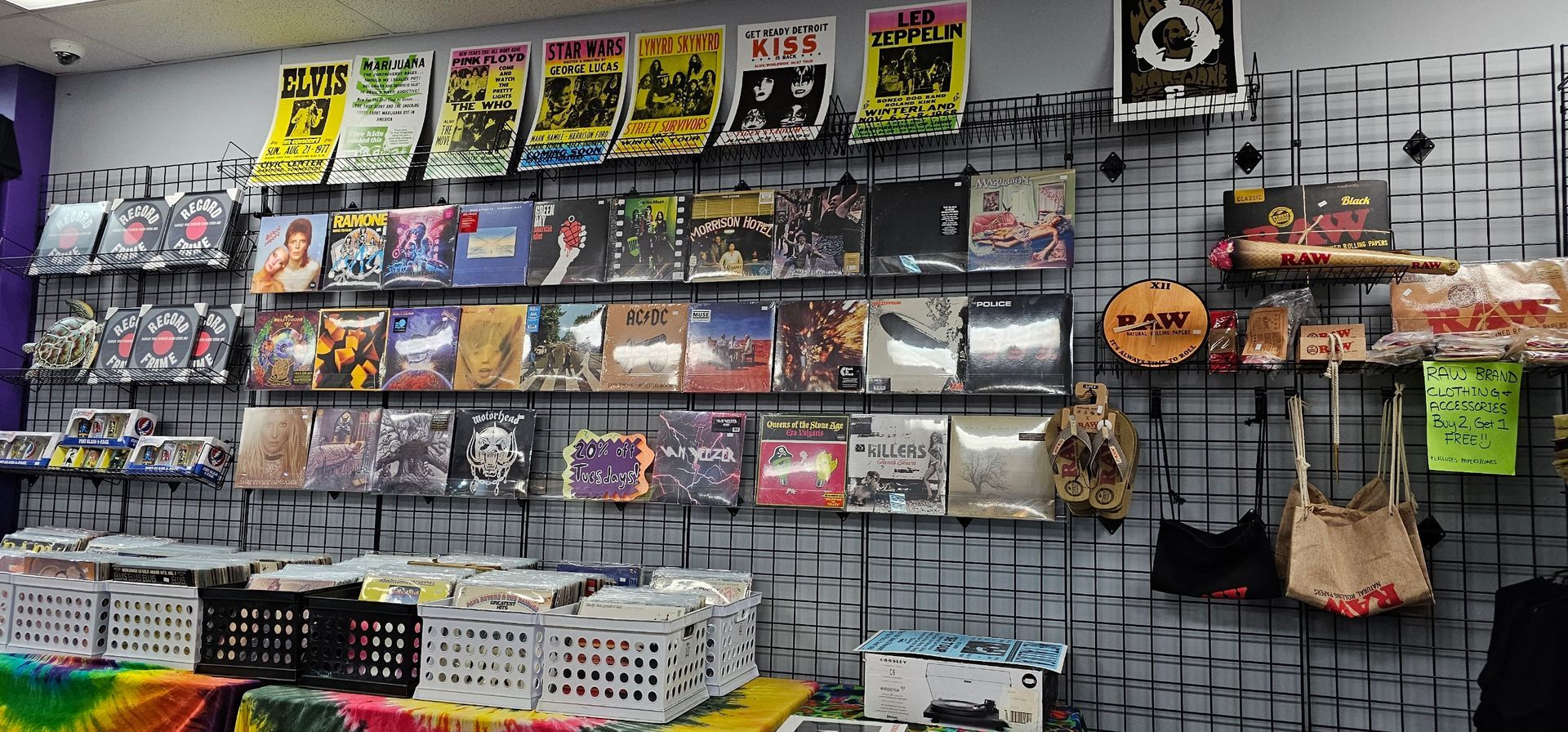 Wall of records, posters, and merchandise in a record store. Display of music albums for sale.