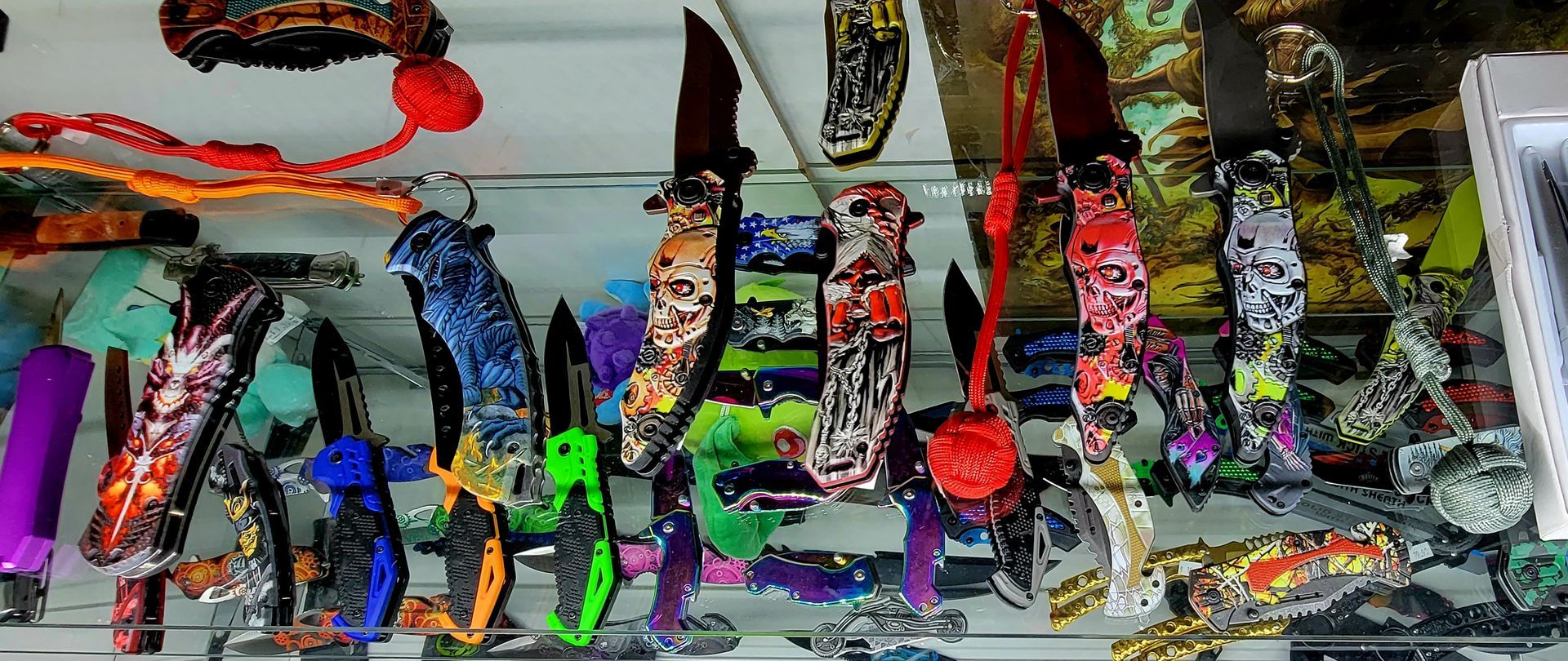 A display case filled with colorful, decorative pocket knives.