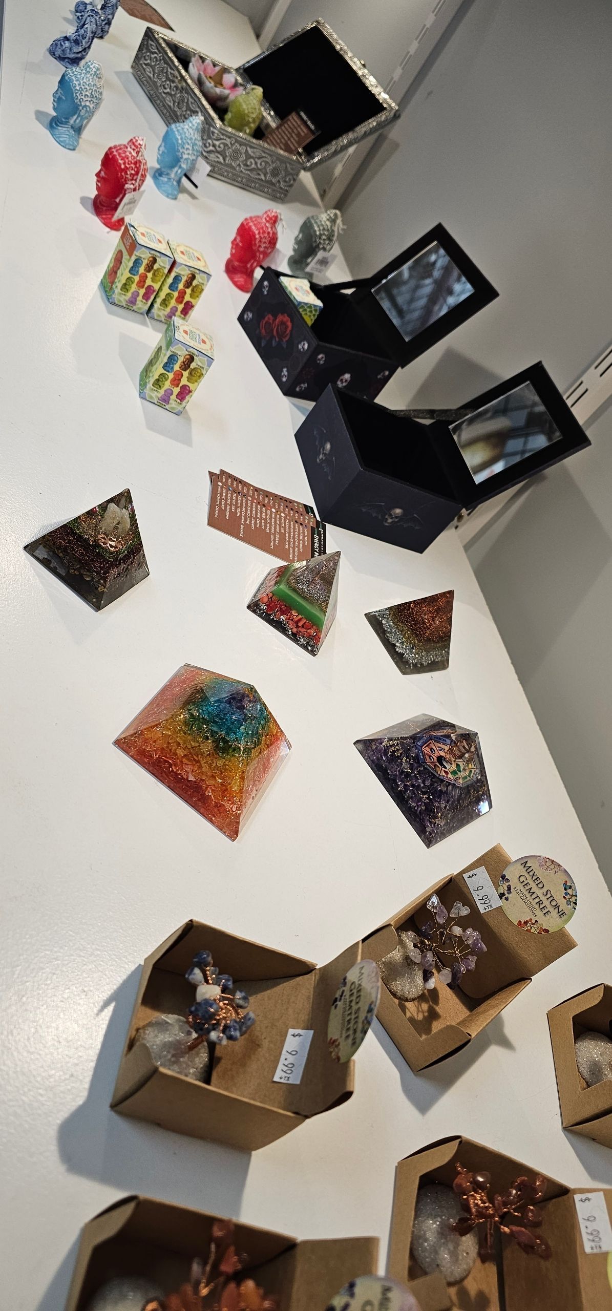 Various colorful resin art pieces and small boxes displayed on a white surface.