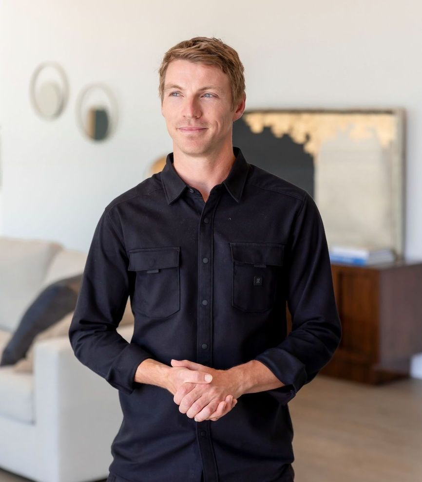 A man in a black shirt is standing in a living room