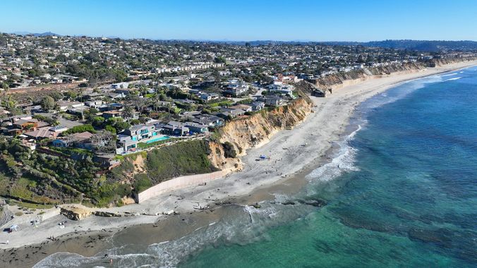 An aerial view of a beach with a city in the background.