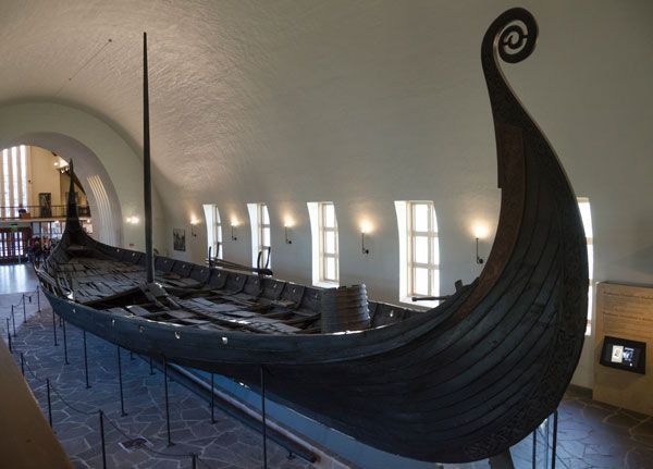 A large viking ship is on display in a museum