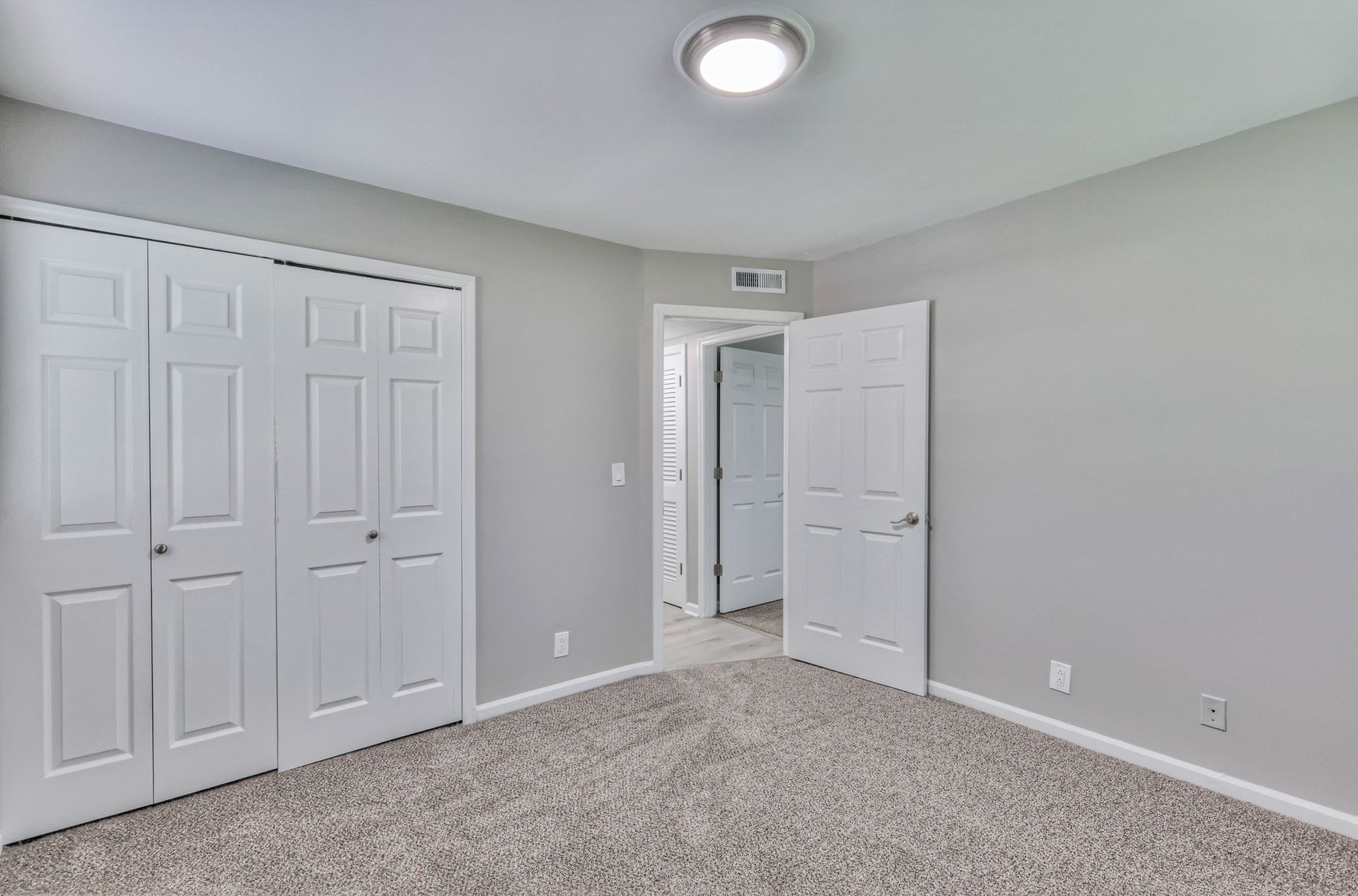 Photo of a bedroom with a closet that has two sliding doors
