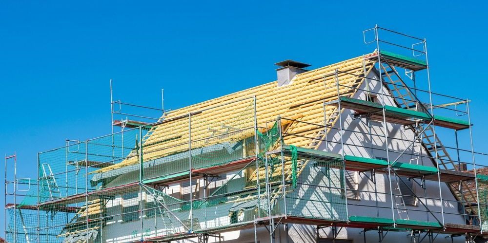 A house roof getting repaired with scaffolding around it — QB Roof Tiling Services In Maroochydore, QLD