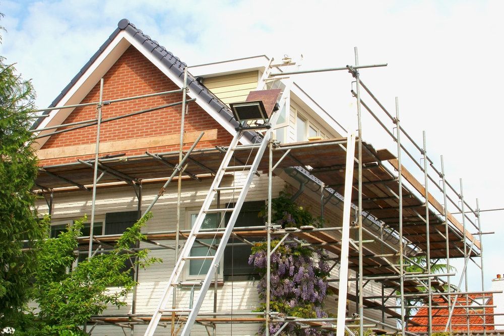 A roof is being repaired with scaffolding and a ladder — QB Roof Tiling Services In Maroochydore, QLD