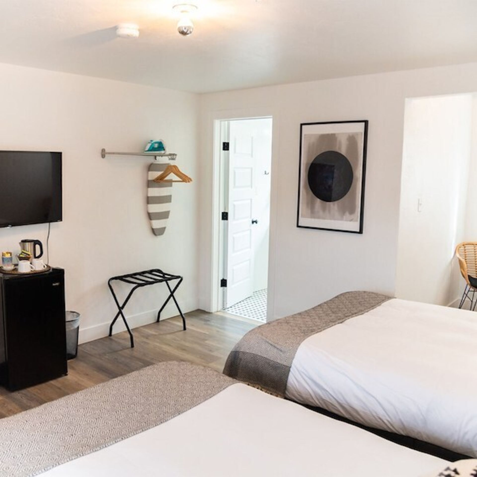 Hotel room with two beds, a TV, and an ironing board.