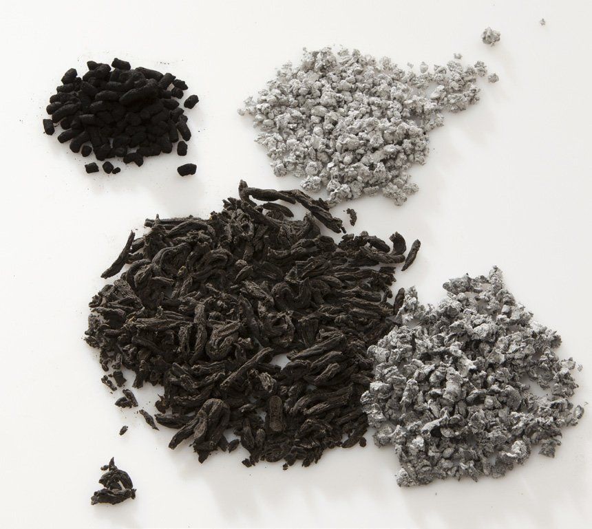 Three piles of different types of biosolids on a white surface