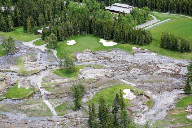 An aerial view of a golf course surrounded by trees. with heavy flooding