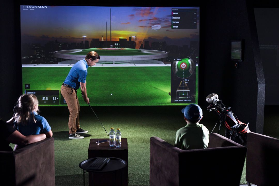 family playing golf in the simulator