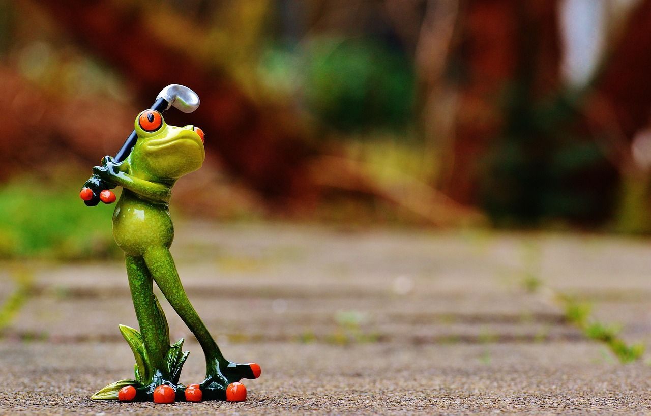 image of a ceramic frog swinging a golf club