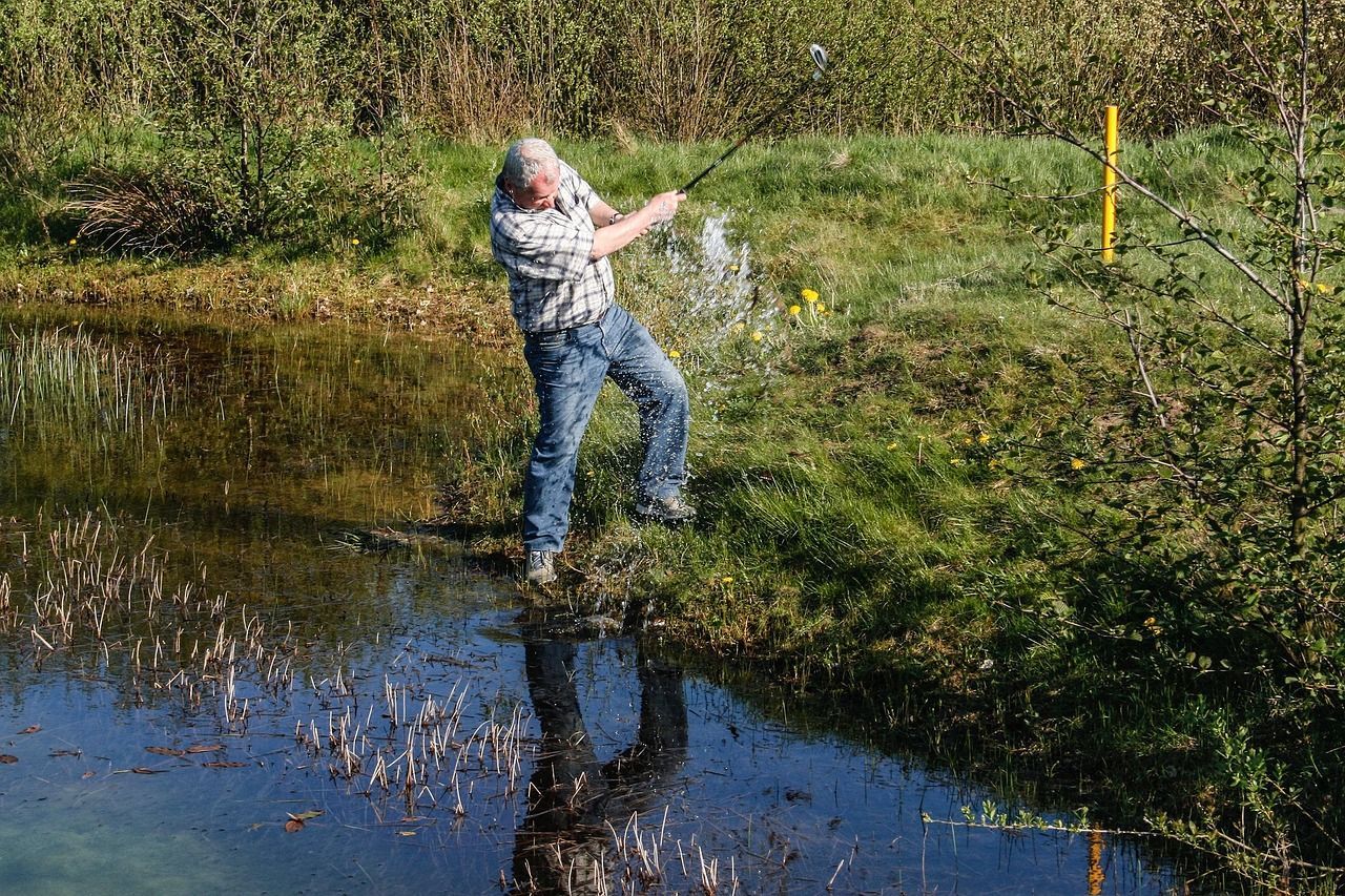 golfer chip shot from the water and reeds