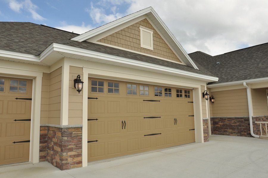 A house with three garage doors and a roof
