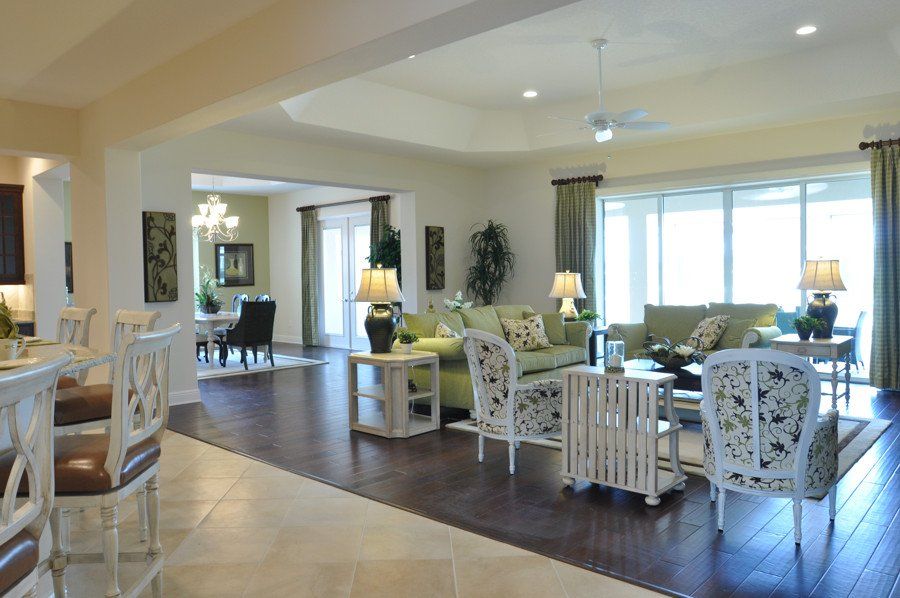 A living room with a green couch and white chairs