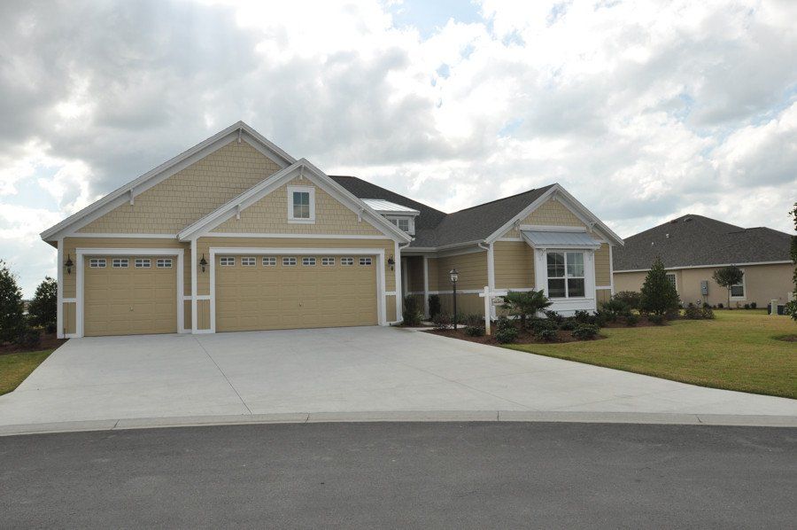 A house with two garage doors and a concrete driveway