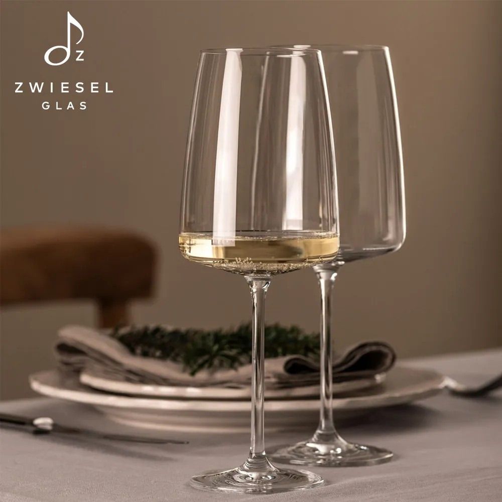 兩隻透明的葡萄酒杯。一隻裝滿了紅葡萄酒和白葡萄酒，另一隻空著。