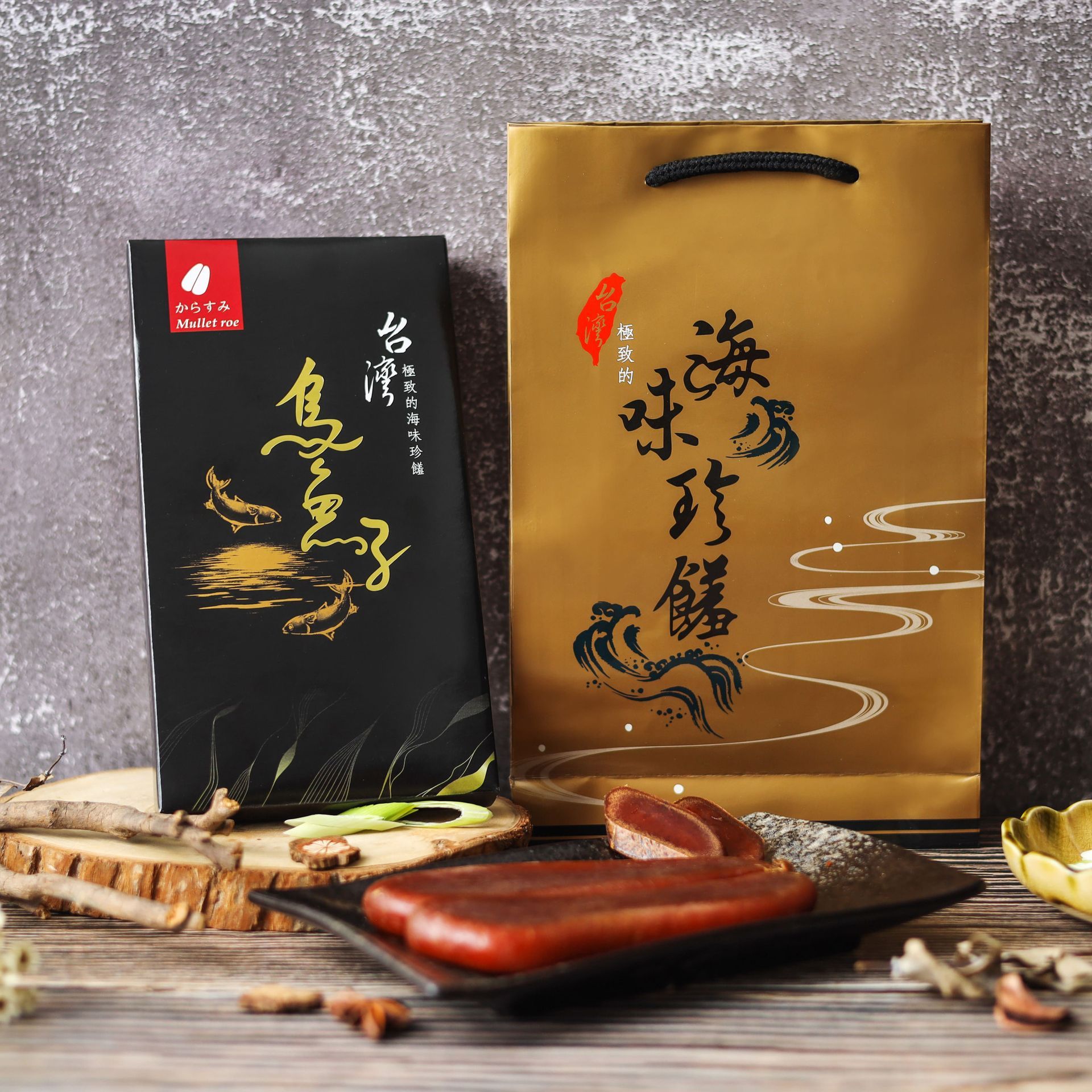 盤子裡放著兩顆乾枯的紅棕色鯔魚子，旁邊是一個印有金色漢字的黑色盒子。