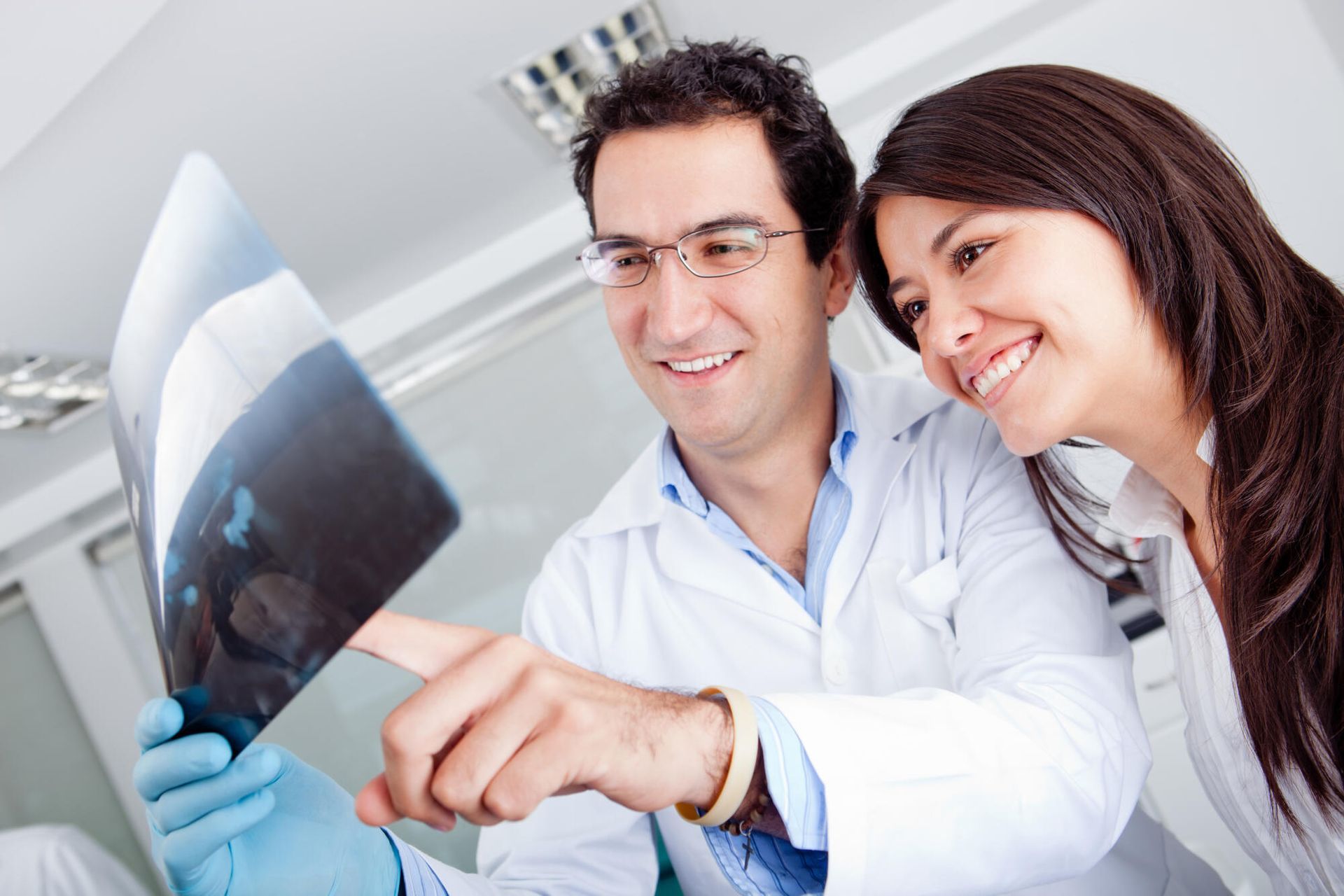 A man and a woman are looking at an x-ray together.