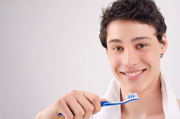young man, brushing his teeth
