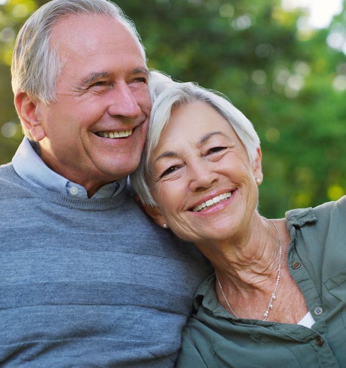 A man and a woman are hugging and smiling for the camera.