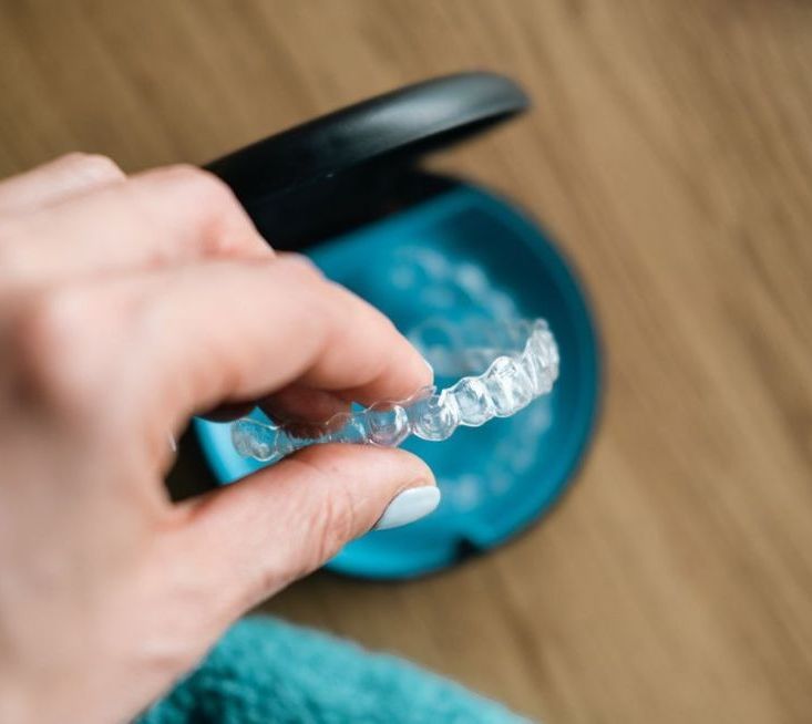 A person is holding a clear brace in their hand.